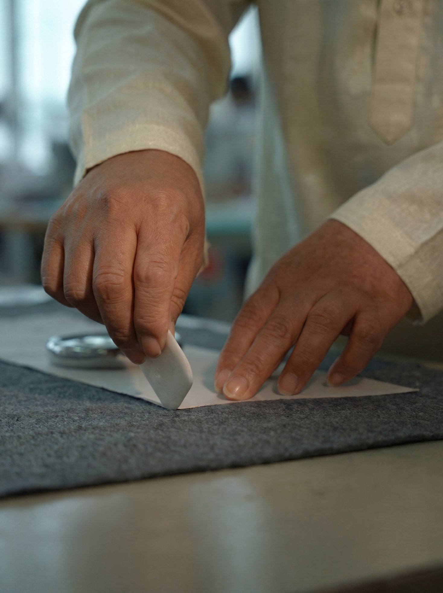 Artisanal fabric marking before cutting, showing how Eastern form shapes the silhouette and quiet structure of a CocoonCash luxury wool coat.